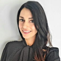 a woman wearing a black shirt and tie is smiling for the camera