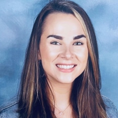 a woman with long brown hair is smiling in front of a blue background